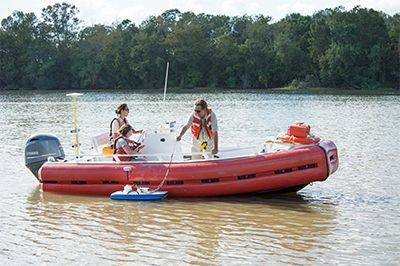 Boat measuring river discharge across channels.